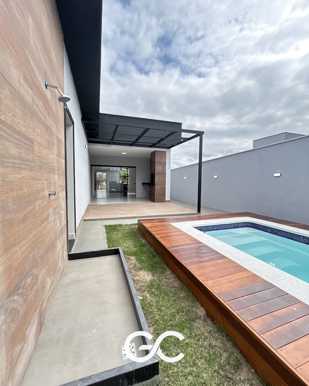 Piscina com deck de madeira e área coberta no Alphaville 1
